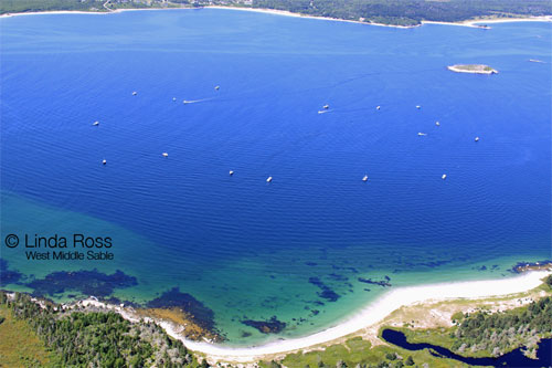 Fishing boats beginning to outline the fish farm site boundary.