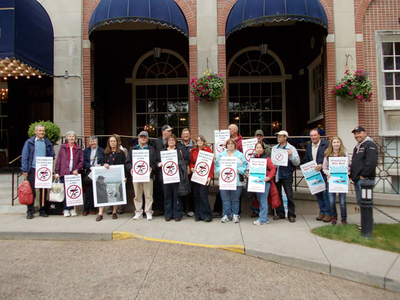 Friends group photo standing in front of Lord Nelson, showing their signs